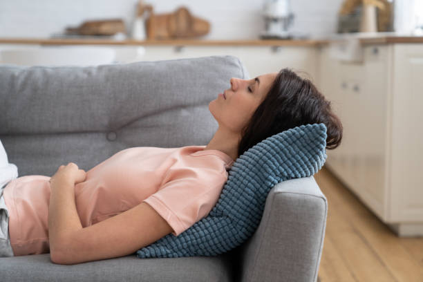 istock Young woman lying on on pillow on couch, resting, relaxing, sleeping after completing house working 1308513062
