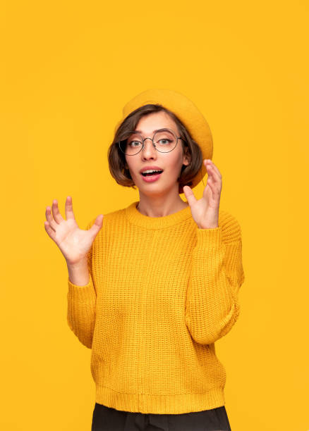 istock Surprised woman in yellow clothes looking at camera 1308520785