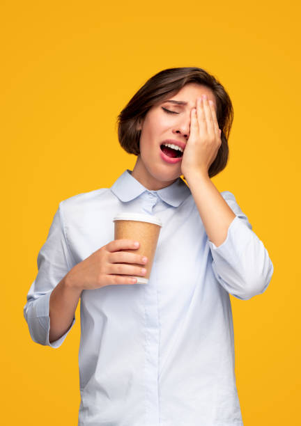 donna stanca che si strofina gli occhi mentre fa il caffè - yawning women drink coffee cup foto e immagini stock