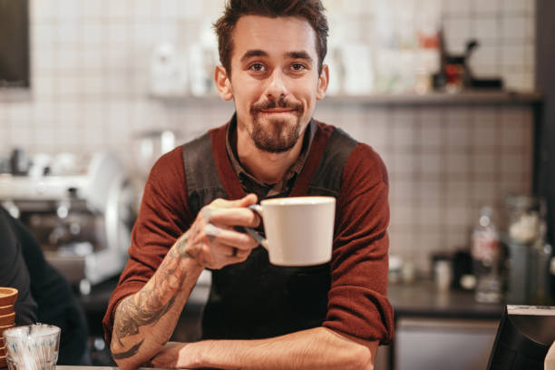 istock Cheerful barista with cup of coffee 1308520907