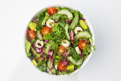 Mixed vegetables salad with cherry tomato, lettuce, radicchio, endive palm heart, cucumber, avocado, arugula, and onion.