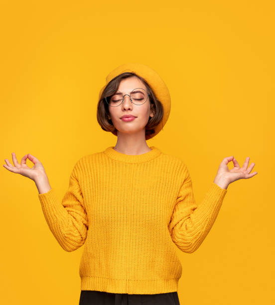 istock Stylish young woman meditating with closed eyes 1308531486