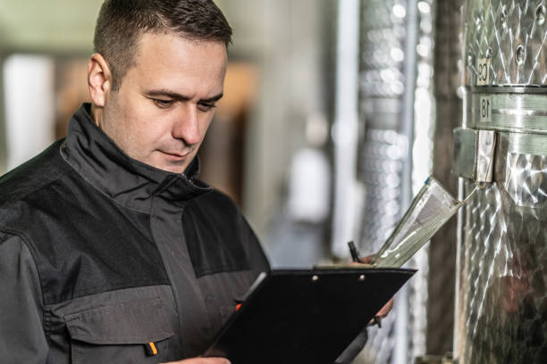 istock Side view of adult man winemaker at winery checking quality while standing between the silos controlling alcohol drink fermentation process - real people traditional and industry wine making concept 1308534312