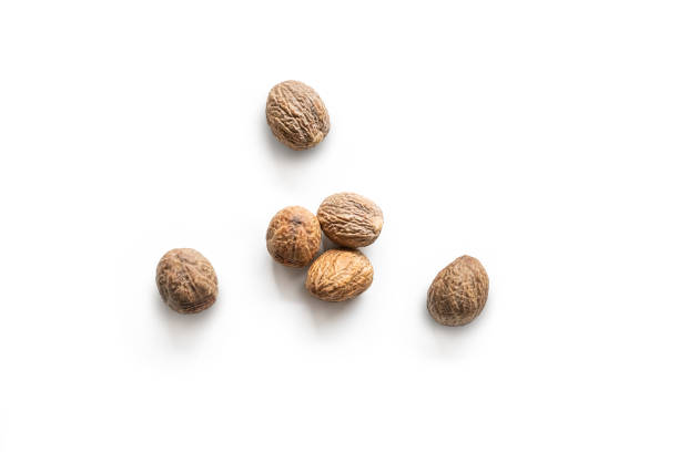 Organic whole nutmegs isolated on a white background Organic whole nutmegs isolated on a white background nutmeg stock pictures, royalty-free photos & images