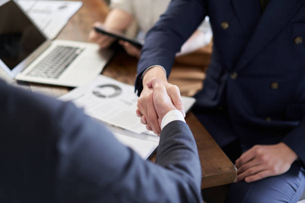 mains des hommes d’affaires asiatiques se serrant la main - coalition businessman business handshake photos et images de collection