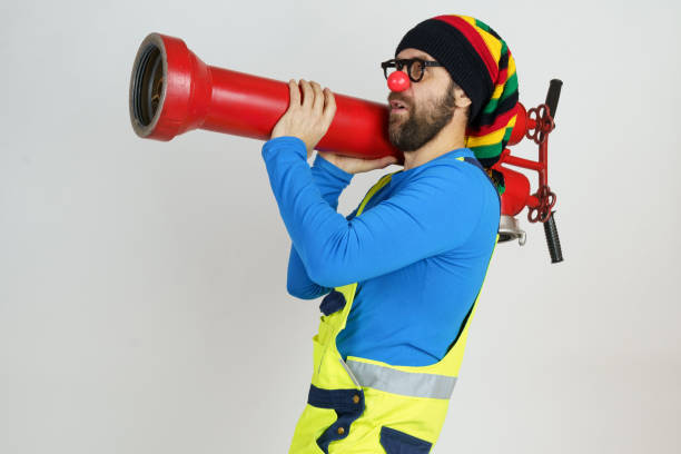 istock The clown firefighter holds a fire pump in his hands like a grenade launcher. 1308546389