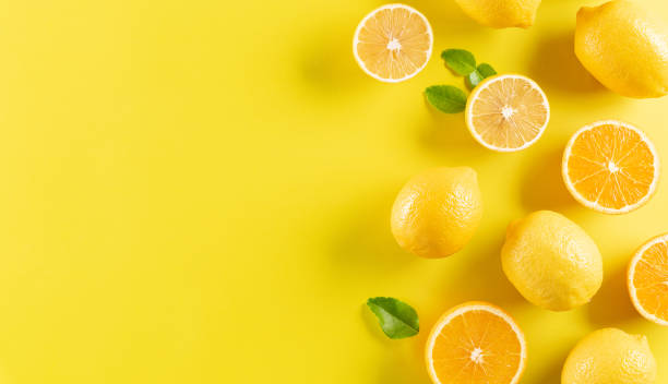 istock Summer composition made from oranges, lemon and green leaves on pastel yellow background. Fruit minimal concept. 1308550009