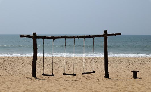 A Panoramic Twilight picture of deserted Wooden Swings on the Sands of Padubidri beach during the Covid 19 restrictions in Karnataka,India.