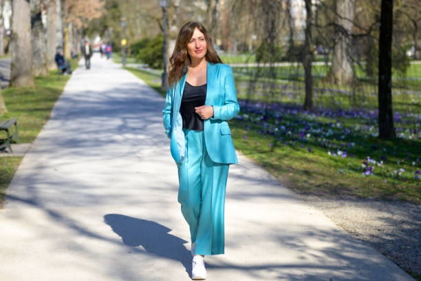 stylish attractive middle-aged woman in turquoise pants suit - fato de senhora imagens e fotografias de stock