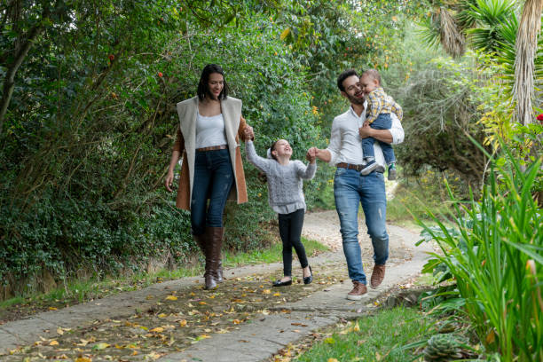 Family consisting of mother, father and children walking through the field Family made up of mother, father and children of Latin ethnicity of different ages are walking through the field latin script stock pictures, royalty-free photos & images