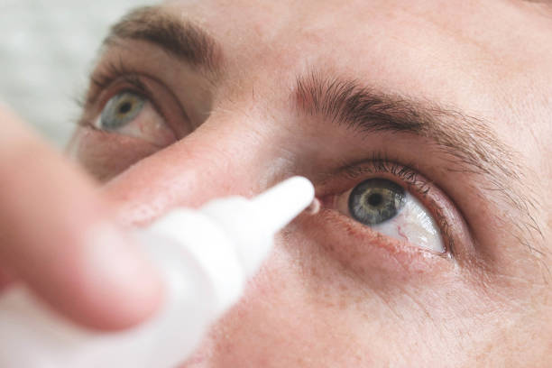 istock Man drops eye drops install lenses.Preservation and solution vision problems. Eye diseases are recognized. Drops before putting on lenses or before removing at end day 1308558815