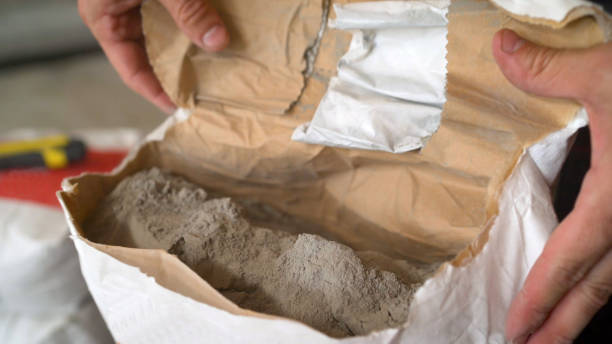 Cement or grout in a construction bag. Cement powder in bag package. Dry mortar for laying the floor in a bag. Dry mortar for laying the floor in a bag. Cement or grout in a construction bag. Cement powder in bag package. cement bag stock pictures, royalty-free photos & images