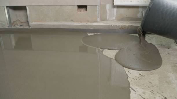 istock Leveled dry cement-sand mixture on the floor surface in a building under construction. Concrete work on filling floors with hand tools. The process of filling the floor with mortar. 1308561053