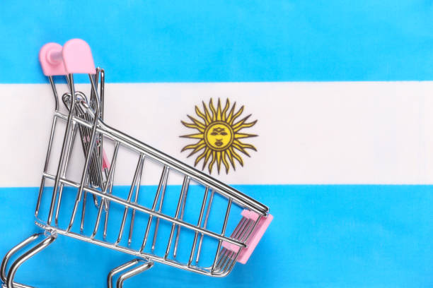 Mini supermarket trolley on blurred Argentina flag background. Shopping concept.