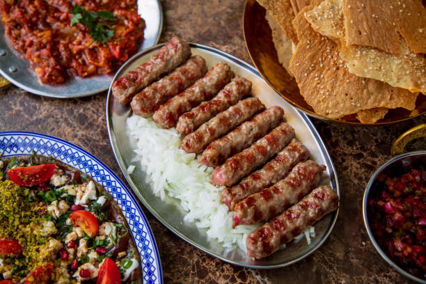 cevapi con cipolla su piatto ovale, piatti di insalata della cucina mediorientale e pane lavash - cooked in a row traditional culture indoors foto e immagini stock