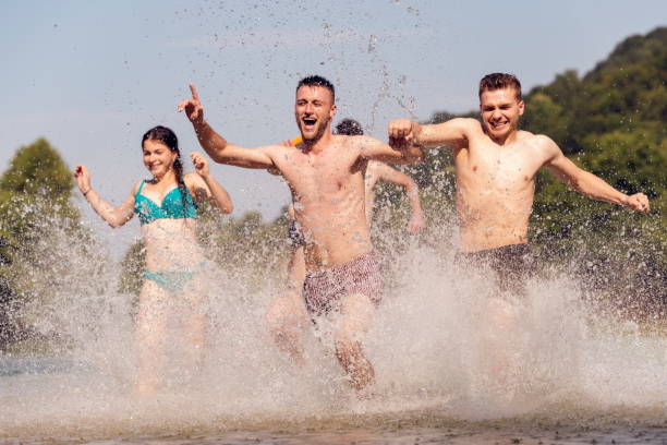 istock group of happy friends having fun on river 1308568054