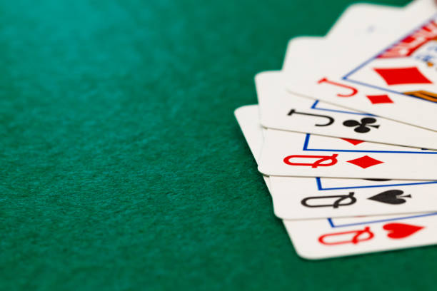 istock Poker chips and playing cards on black background 1308568636