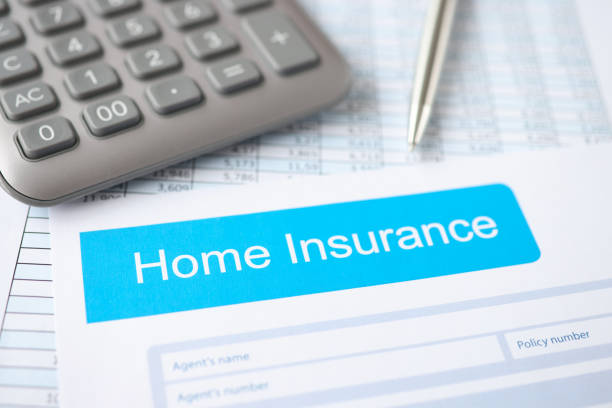 istock Home insurance contract, along with calculator and pen, lies on table 1308568681