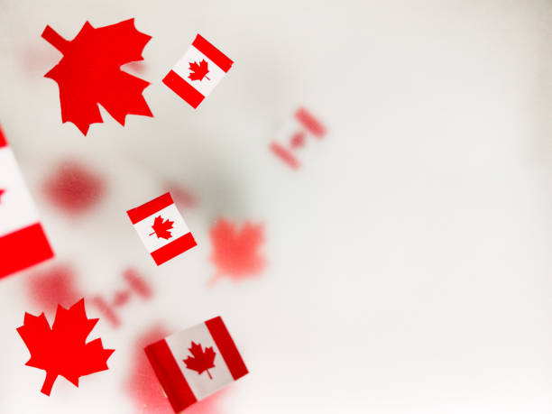 istock July 1, Happy Canada Day. Red maple leaves and flags on a transparent foggy background. A multi-tiered photo, a Memorial day card. The concept of freedom and patriotism, independence and victory 1308569444