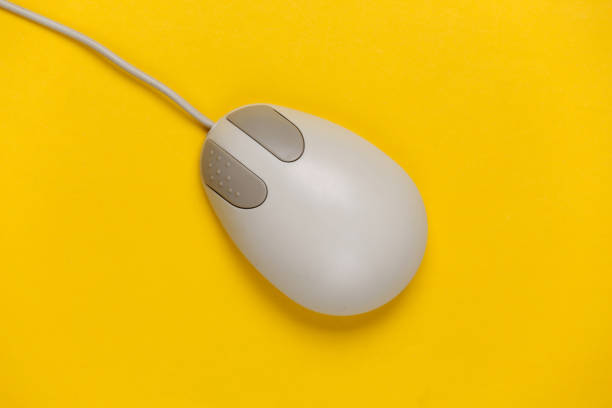 istock Old-fashioned retro pc mouse on a yellow background. Top view 1308569777