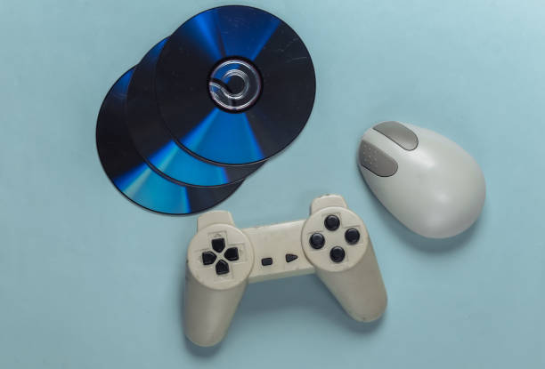 istock Retro entertainment. Old-fashioned pc mouse, gamepad and CD's on blue background. Top view. Flat lay 1308569834