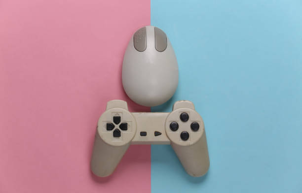 istock Retro entertainment. Old-fashioned pc mouse, gamepad on blue pink background. Top view. Flat lay 1308569840