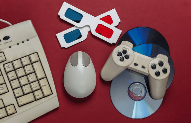 istock Retro entertainment. Old-fashioned keyboard, pc mouse, compact discs, gamepad, anaglyph stereo glasses on red background. Top view. Flat lay 1308569972