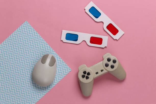 istock Retro entertainment. Old-fashioned pc mouse, gamepad, anaglyph stereo glasses on blue pink background. Top view. Flat lay 1308570018