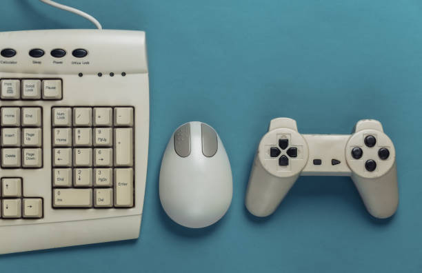istock Retro entertainment. Old-fashioned pc mouse, keyboard, gamepad on blue background. Top view. Flat lay 1308570056