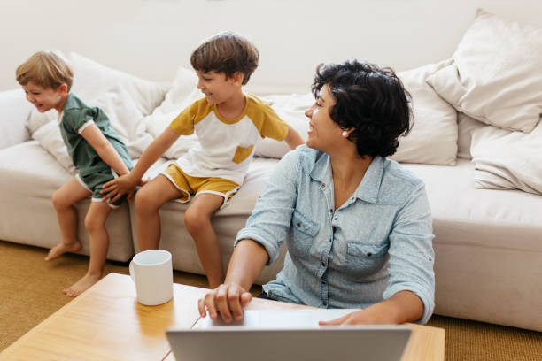 istock Kid playing at home with mom working on laptop 1308571851