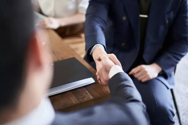 Photo of Asian businessman shaking hands in business talks