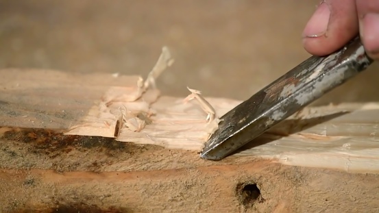 close up of wood carving with chisel
