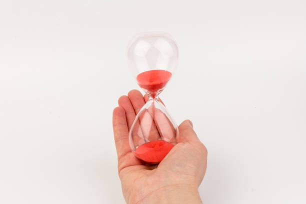 istock Hand holding a hourglass isolated on white background 1308575658