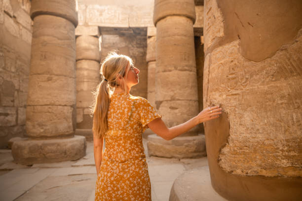 istock Woman explores ancient temple and touches column 1308576406