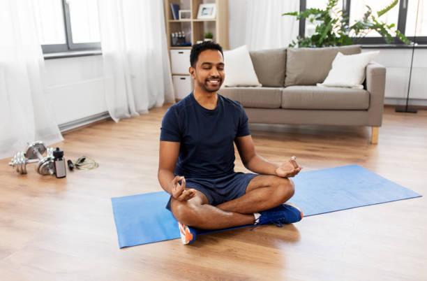 istock indian man meditating in lotus pose at home 1308577744