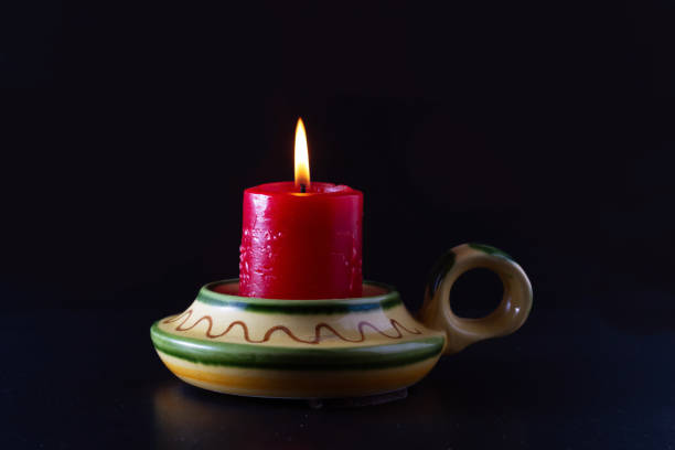 istock A lit red candle in a ceramic candlestick. 1308578887