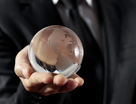 Businessman holding glass globe.