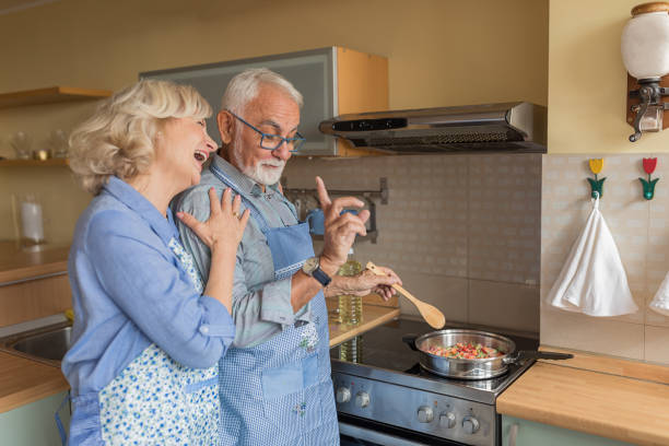 istock Happy Older Man and his Wife are Spending a Nice Time While Enjoying in Dinner Preparation at Home. 1308580336