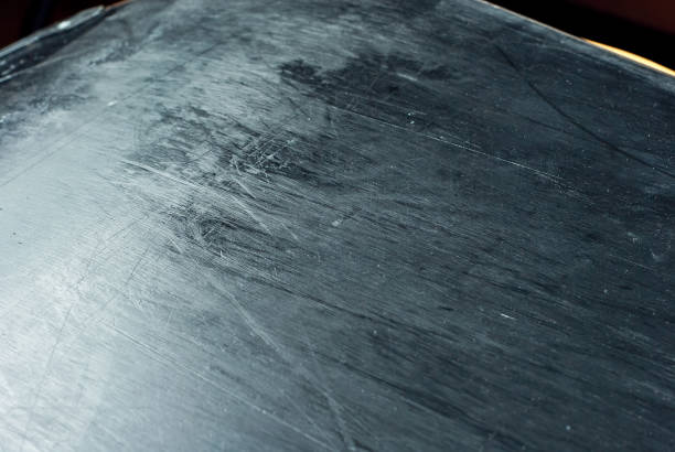 istock White scratches and dust on black plastic. Scratches on a snowboard close up. Paraffin application and ski equipment service. 1308582091