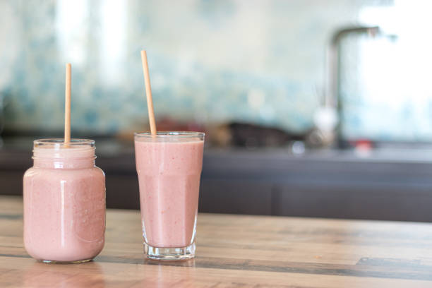 Two smoothie glasses with paper straws and copy space stock photo