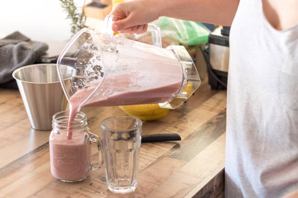 istock Pouring smoothie into a glass jar 1308583128