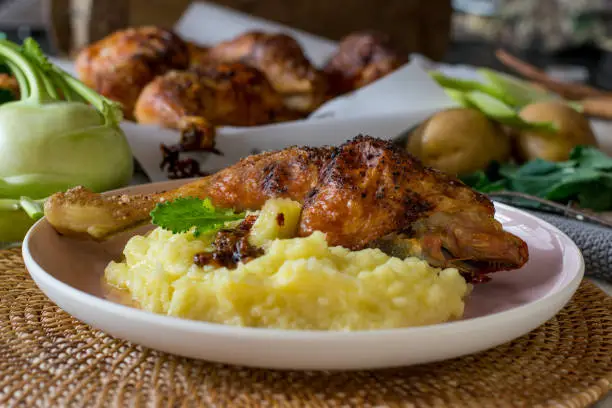 grilled chicken legs with potato, kohlrabi puree served warm on a plate for dinner. Table background. Ready to eat