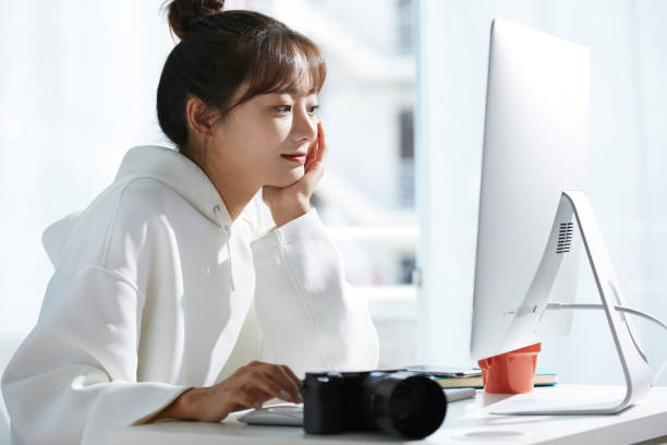 創造的な仕事をしている若いアジアの女性 - デスクトップ型パソコン ストックフォトと画像