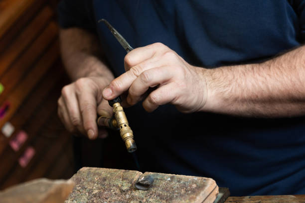 istock goldsmith jeweler soldering a silver ring on the workbench with a soldering. 1308587781