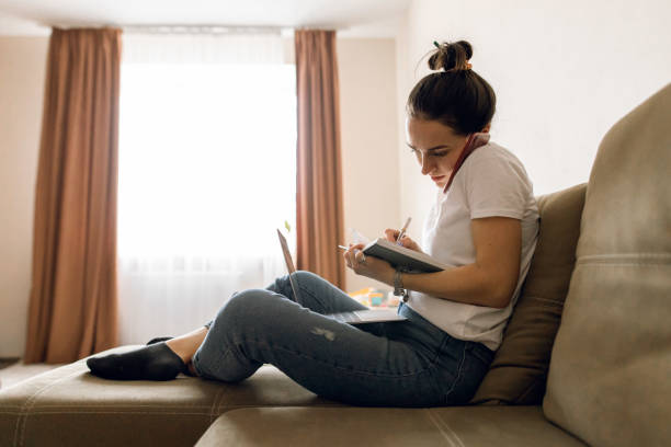 istock Young woman working from home using a laptop, notebook, and a smartphone 1308589690
