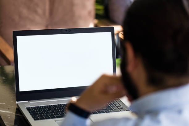 hommes utilisant l’ordinateur portatif avec l’écran blanc - regarder par dessus son épaule photos et images de collection