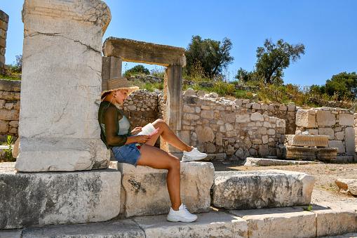 A woman who does not give up on the difficult ancient city roads climbs to the extreme point of thermesos.