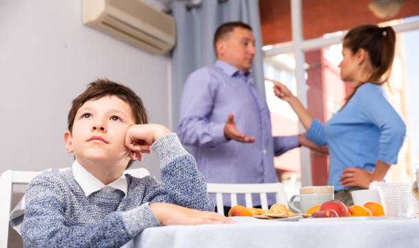 istock Unhappy boy with quarreling parents 1308592545