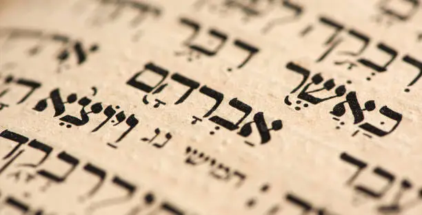 Closeup of hebrew word Abraham in Torah page. Selective focus. Banner