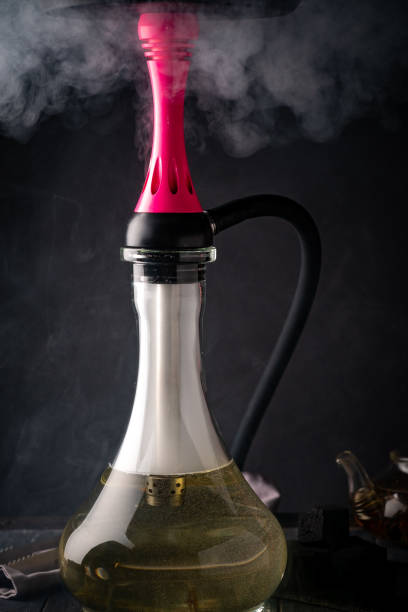 istock Smoking hookah on a black wooden background 1308593980